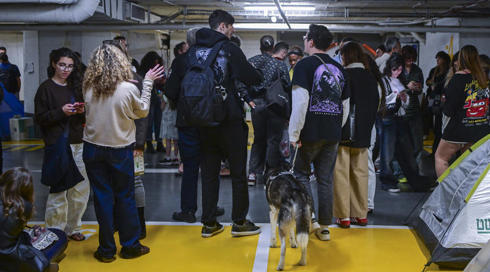 אנשים תופסים מחסה בחניון בזמן אזעקות בתל אביב. 09.03.26